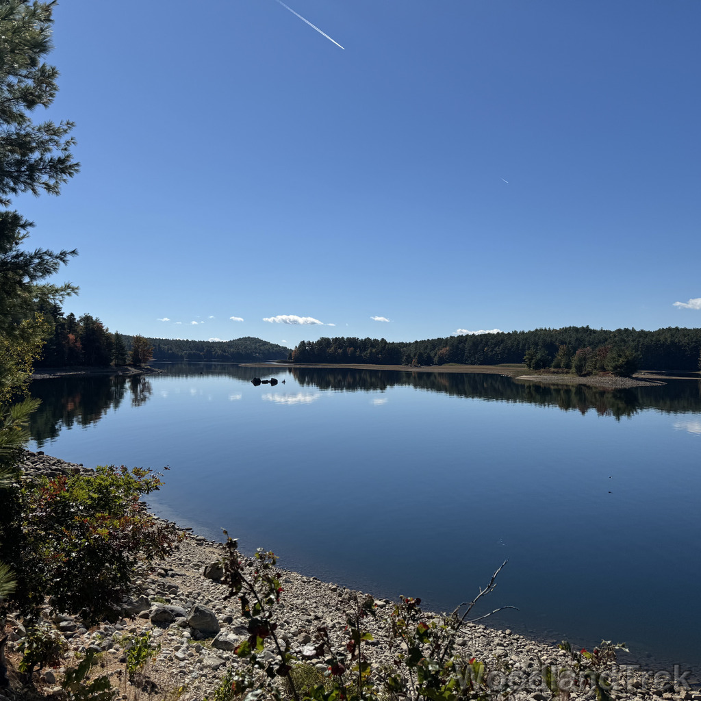 Calm blue waters of Quabbin Reservoir reflecting a few clouds in the sky