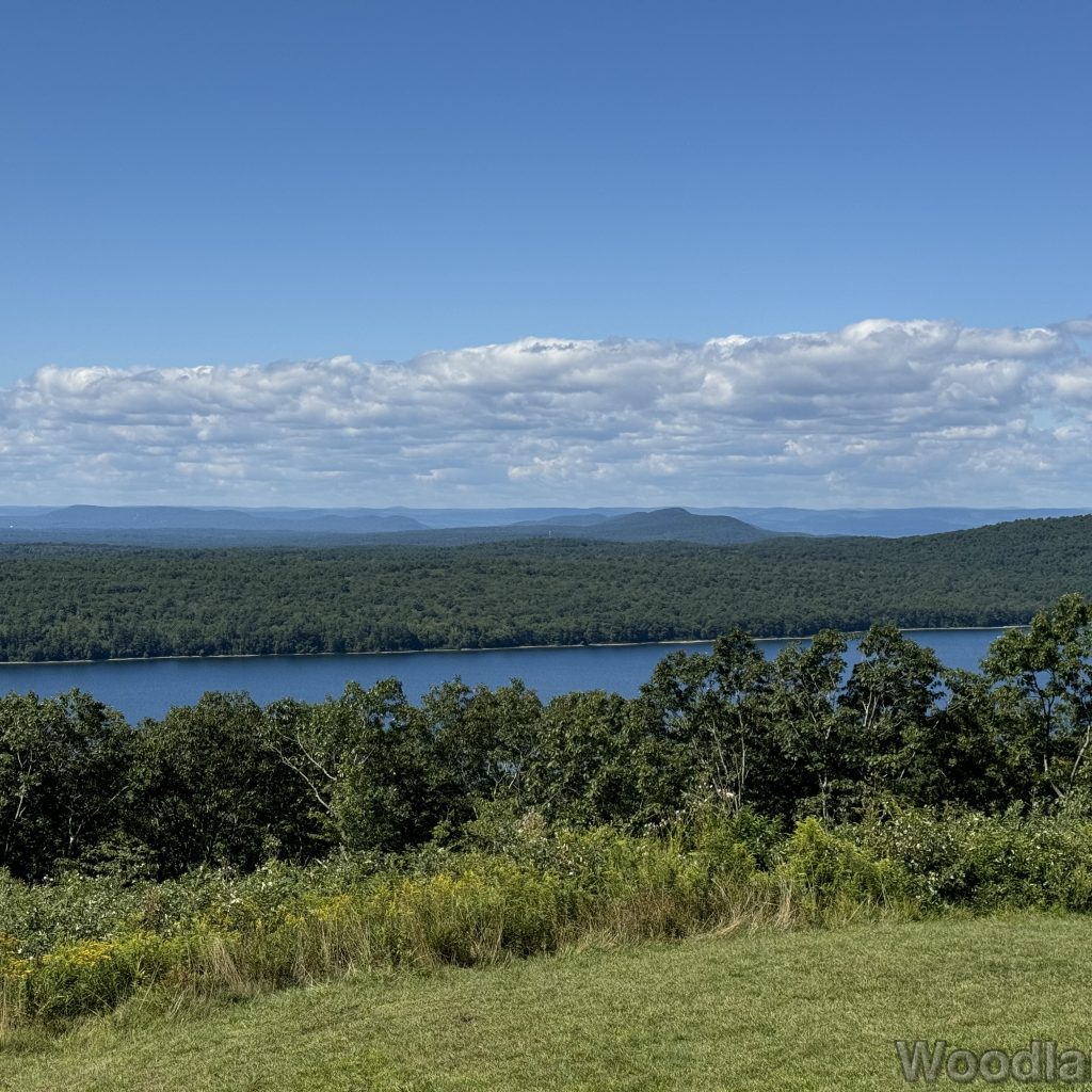 View from Quabbin Hill showing mostly forested hills and distant mountains, with a small section of Quabbin Reservoir visible