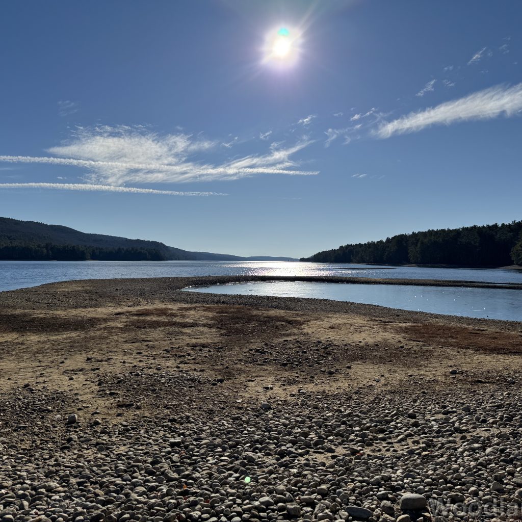 Bright sun reflecting off the water with a gravel bar extending into Quabbin Reservoir