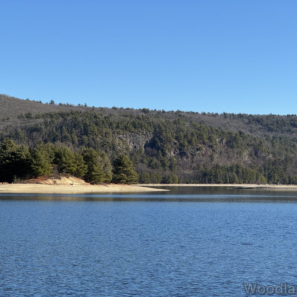 Steep rocky cliff and sandy coastline across Quabbin Reservoir