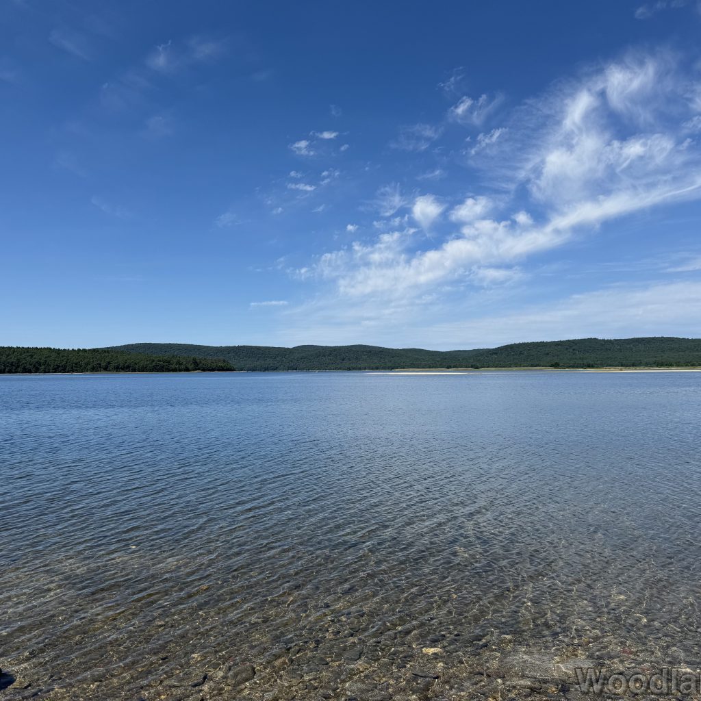 Clear water at Quabbin Reservoir showing rocky bottom, gentle ripples, and distant shoreline