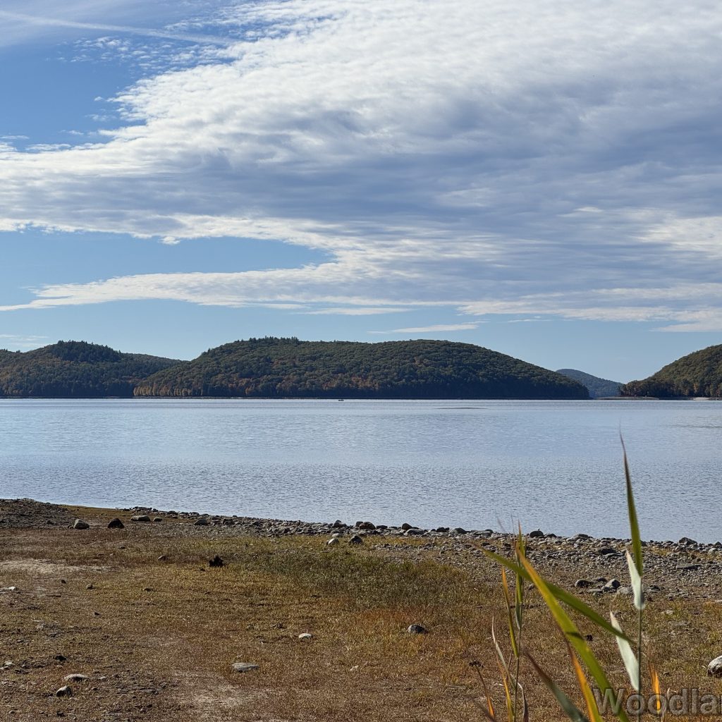 View of Mount Zion from the end of Rabbit Run Rail Bed at Quabbin Reservoir with calm, reflective water