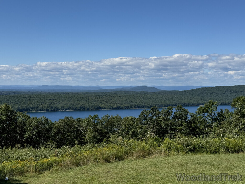 View from Quabbin Hill showing mostly forested hills and distant mountains, with a small section of Quabbin Reservoir visible