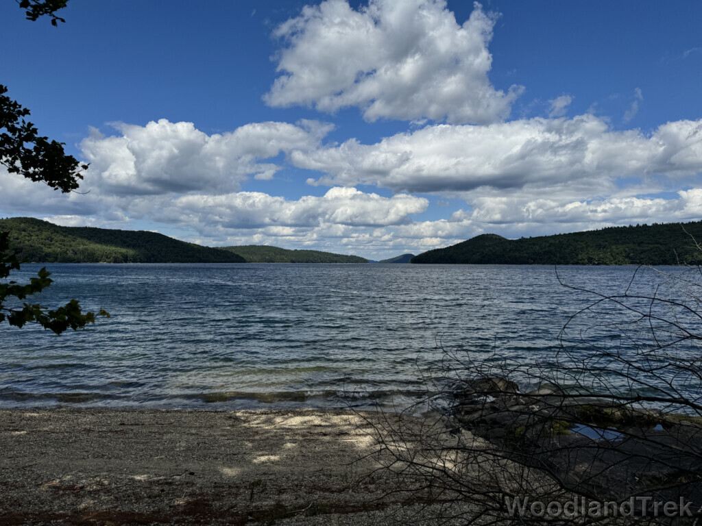 Blue water with gentle waves at Quabbin Reservoir, distant islands, and clouds casting shadows
