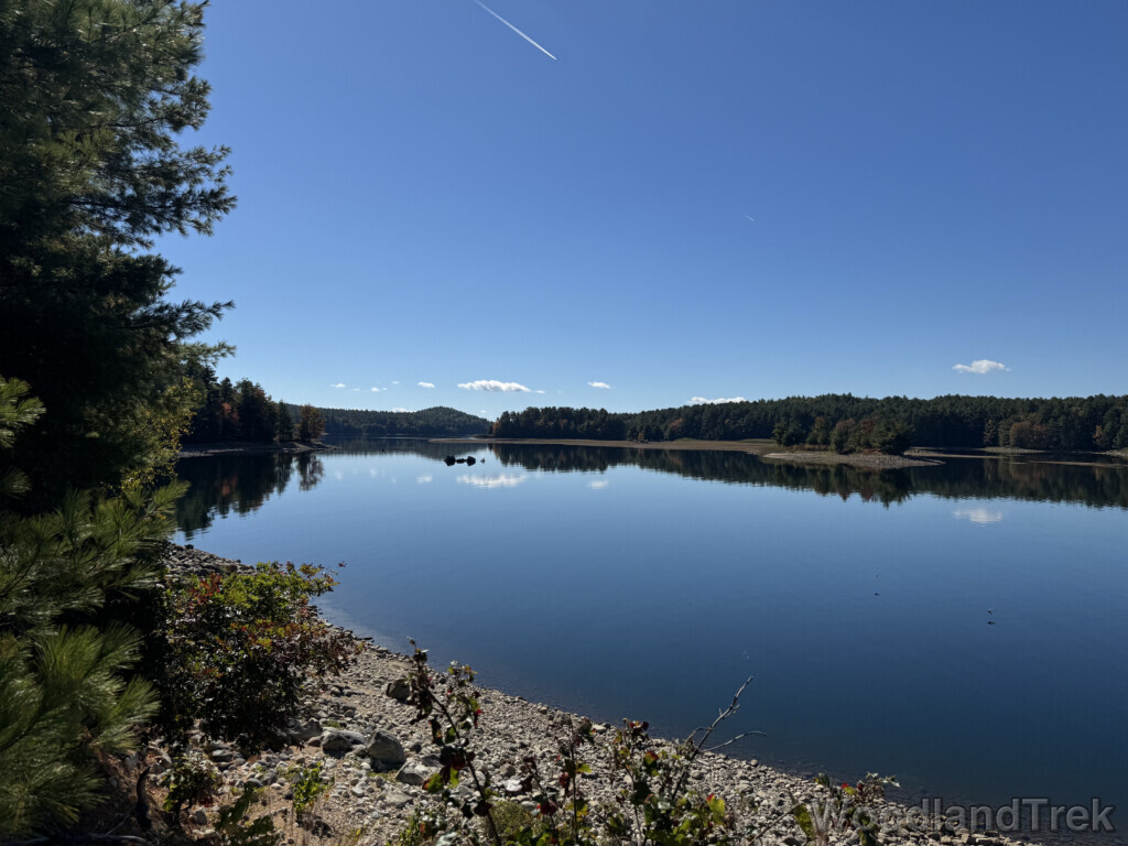 Calm blue waters of Quabbin Reservoir reflecting a few clouds in the sky