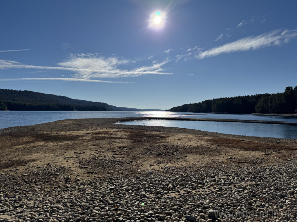 Bright sun reflecting off the water with a gravel bar extending into Quabbin Reservoir
