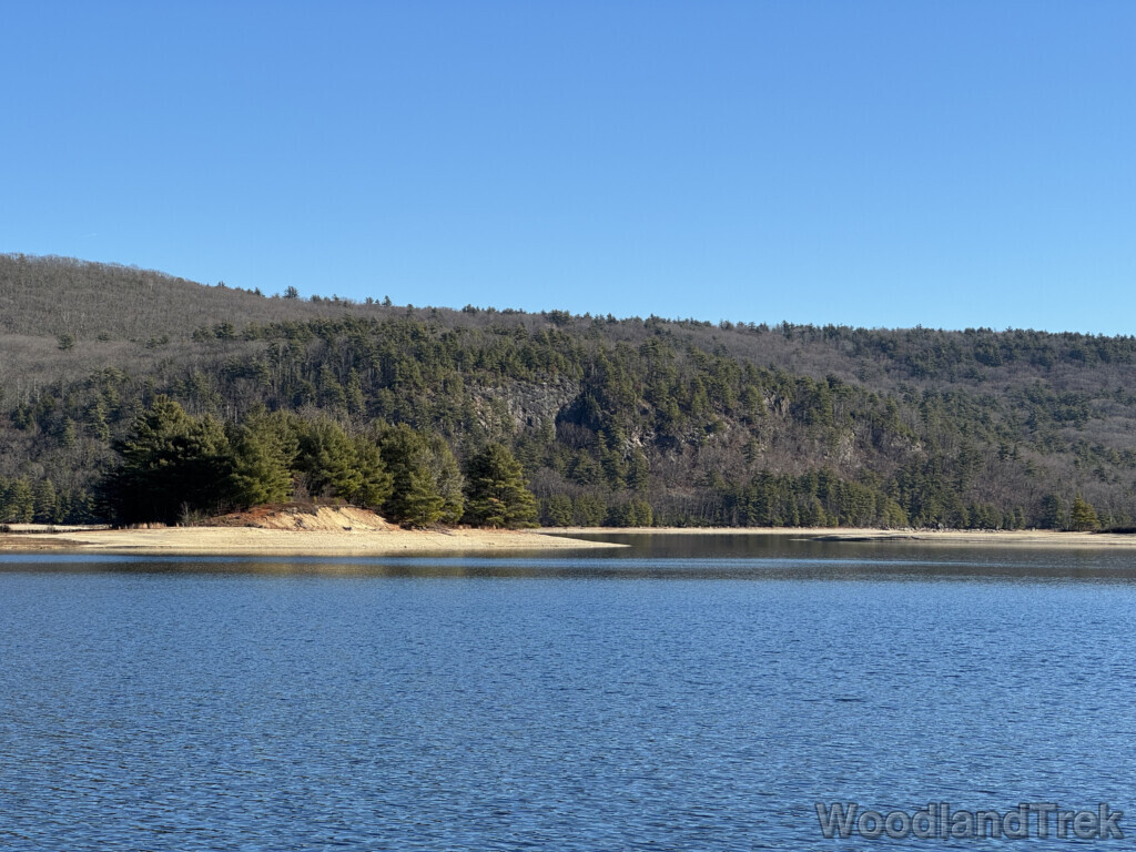 Steep rocky cliff and sandy coastline across Quabbin Reservoir