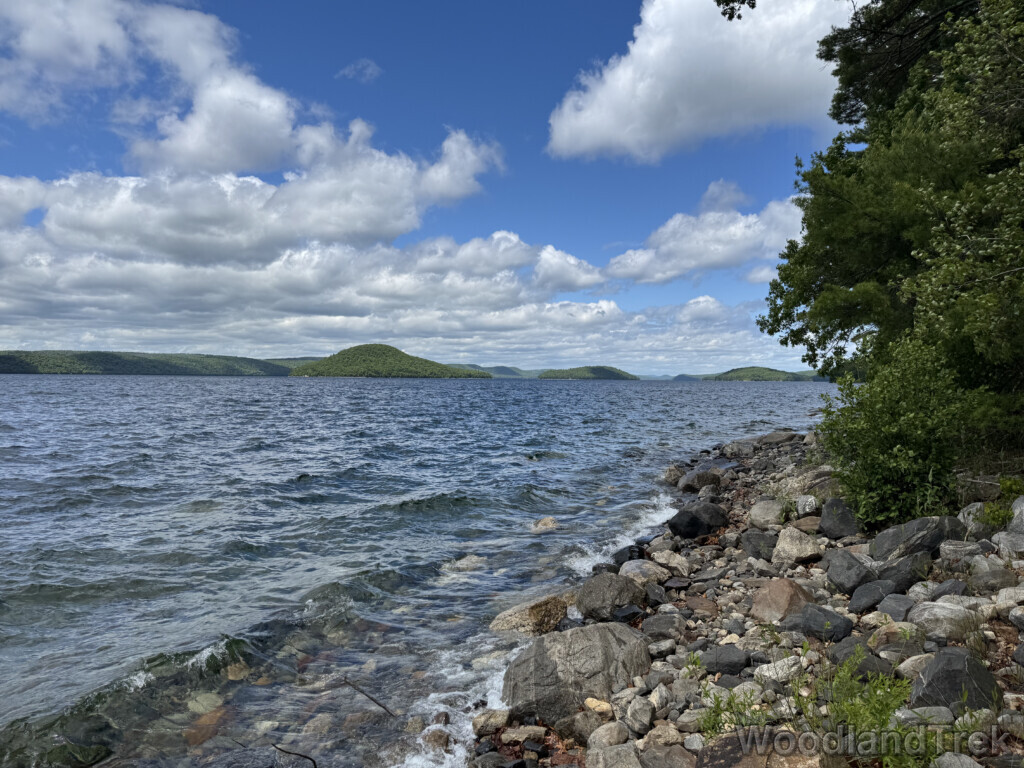 Quabbin Reservoir with choppy waves, clear water, rocky shoreline, and distant islands and hills