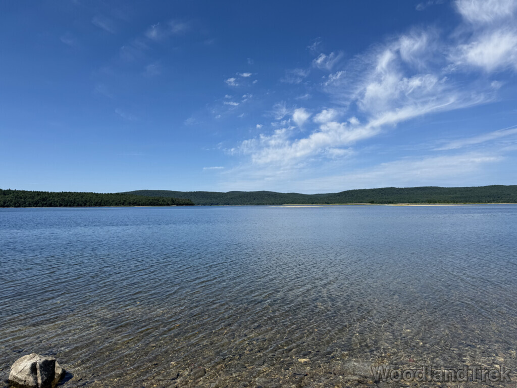 Clear water at Quabbin Reservoir showing rocky bottom, gentle ripples, and distant shoreline